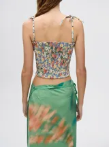 Top corto negro con textura fruncida, tirantes finos con lazos ajustables y corte crop.