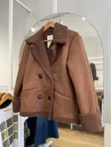 Chaqueta marrón con forro tipo corderito, doble botonadura y cuello con solapas.