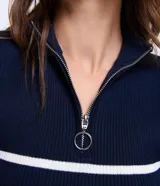 Blusa de tejido de punto acanalado color blanco con rayas horizontales azul marino, cuello polo con cierre metálico y mangas cortas.