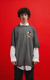 Remera gris de manga corta con cuello redondo y calce oversize. Estampado de Mickey Mouse en el pecho.