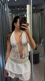Top blanco de encaje con escote halter y espalda descubierta.