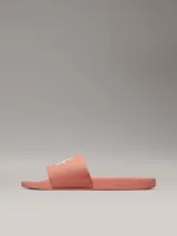 Ojotas color salmón con logo Calvin Klein Jeans en blanco.