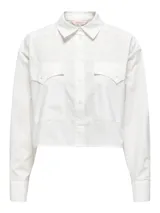 Camisa blanca de corte cropped, con cuello clásico, mangas largas con puños abotonados y dos bolsillos de parche en el pecho.