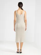 Vestido largo tejido en jersey con hilo lurex dorado, de corte recto, escote bote y aberturas laterales.