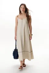 Vestido largo color crudo con breteles finos y costuras a la vista en color azul.