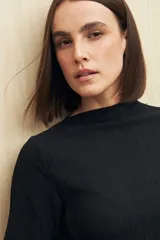 Top negro de textura acanalada con cuello semi alto y abertura lateral.