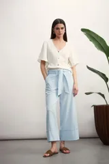 Pantalón blanco de corte ancho, con bolsillos laterales y lazo en la cintura.