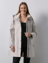 Gabardina impermeable negra, marca Weatherproof, con cierre central oculto y botones a presión. Tiene bolsillos delanteros con cierre, capucha no desmontable y forro interno de abrigo desmontable.