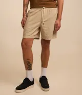 Bermuda masculina color crema, de tejido con textura sutil, cintura elástica con cordón de ajuste y bolsillos laterales.