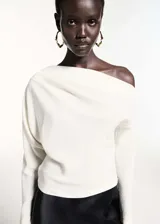 Blusa blanca de poliéster con diseño asimétrico y escote off-shoulder.