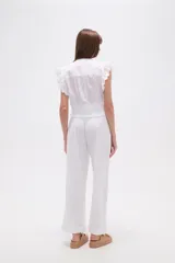 Top blanco de manga corta con escote en V, detalles bordados de hojas y puntos, pinzas, punto smock en la cintura y volados en los hombros.