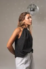 Musculosa negra con lunares blancos, cuello halter y botón en la parte trasera del cuello.