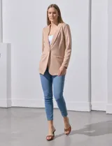 Blazer color beige, entallado, con cuello con solapa, abertura central con botón y bolsillos delanteros.