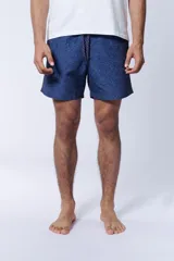 Short de baño azul con estampado de hojas en tonos más oscuros.