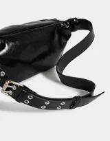 Riñonera negra de cuerina con múltiples bolsillos con cierre y correa ajustable con hebilla metálica.