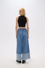 Pantalón de jean azul de corte ancho y tiro alto, con bolsillos y pinzas.