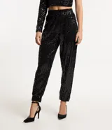 Pantalón jogger de lentejuelas negras con cintura elástica y puños ajustados.