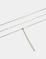 Collar corto dorado de tres capas con diferentes tipos de cadenas y nudo decorativo.