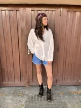Camisa blanca de manga larga con detalle de bolitas en la tela.