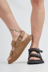 Sandalias negras de cuero con dos tiras ajustables con velcro.