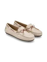 Mocasín color crema con textura de piel de cocodrilo, cordones de cuero marrón con punteras metálicas doradas y suela marrón de goma antideslizante.