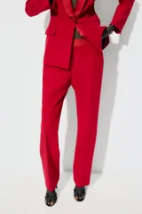 Pantalón negro de tiro alto con corte flare y cinturilla combinada. Presenta bolsillos laterales y falsos bolsillos de vivo en la espalda. Cierre frontal con cremallera, botón interior y gancho metálico.