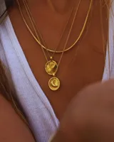 Collar dorado con cadena de eslabones finos y dije redondo con diseño de sol.