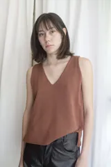 Chaleco de punto color ladrillo con escote en V y sisas amplias. Tejido artesanal en hilado 70% algodón y 30% acrílico.