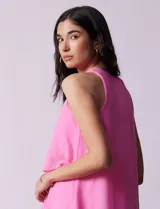 Vestido corto de gasa color fucsia, con escote en V y capas superpuestas. Incluye forro interno a tono.