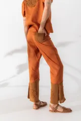 Pantalón de lino color ocre, de tiro medio y pierna recta. Cuenta con detalle de crochet tejido a mano en la pierna baja.