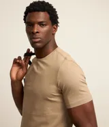 Remera slim de manga corta color salmón, de punto medio, sin estampado y cuello redondo.