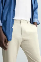 Pantalón largo de vestir gris claro con estampado de cuadros, corte slim fit y cintura elástica. Confeccionado en tejido con alta elasticidad, bolsillos frontales y cierre frontal con cremallera y botón.