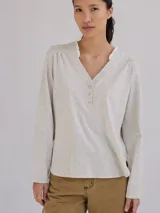 Remera color gris claro con cuello en V y volados de lino en el cuello.