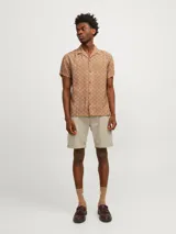 Short de jean color beige, de corte recto, con cinco bolsillos y dobladillo en el ruedo.