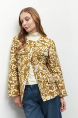 Campera capitoneada con diseño de estampa orgánica en tonos marrón y beige, con grandes botones metalizados.
