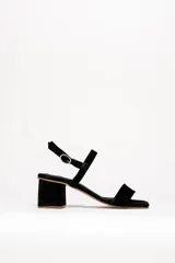 Sandalias negras de cuero gamuzado, con tira fina sobre los dedos y tobillo, y taco cuadrado bajo.