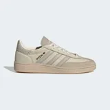 Championes Adidas Handball Spezial color beige con detalles en gris y suela de goma color caramelo. Presentan las tres tiras características de la marca en los laterales y la inscripción "Spezial" en letras doradas.