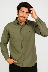 Camisa manga larga color verde militar, con cuello clásico, cierre frontal con botones a tono, dos bolsillos de parche con botón en el pecho y puños abotonados.
