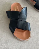 Sandalias bajas de cuero negro con tiras anchas cruzadas y plantilla anatómica color camel.