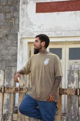Remera blanca de algodón con cuello redondo y manga corta. Estampado pequeño en el frente de una mano haciendo el signo de la paz en color celeste.