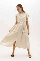 Vestido midi color crema con bordado calado, cuello mao, mangas cortas con volados y cierre frontal con botones.