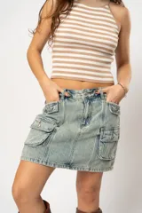 Minifalda de jean celeste con efecto lavado, corte recto y múltiples bolsillos cargo con solapa y botón.