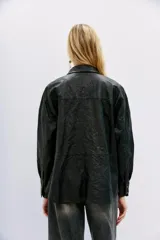 Camisa de cuero ovino negro con efecto arrugado, de moldería amplia, con cuello camisero y botones a presión con logo.