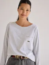 Remera gris de manga larga con cuello redondo y bolsillo en el pecho.