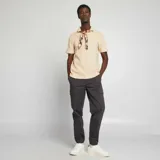 Remera de hombre color beige claro, de punto piqué, con cuello polo y mangas cortas.