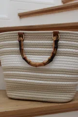 Bolso de mano a rayas en gris pastel, con asas de bambú y diseño espacioso.