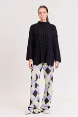 Pantalón de punto con estampado geométrico en tonos lila, verde y beige.