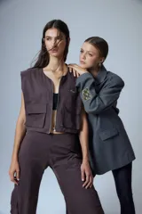Pantalón cargo marrón de gabardina, con cierre metálico lateral, elástico en cintura trasera, recortes delanteros y bolsillos tipo cargo.