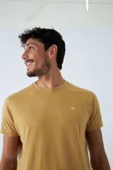 Remera de hombre color mostaza con pequeños detalles en azul, de manga corta, cuello redondo y logo estampado en el pecho.