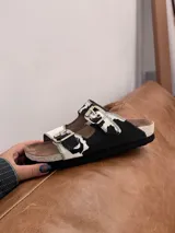 Sandalias con estampado de vaca, con hebillas plateadas y suela de corcho.